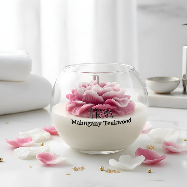 Round glass jar candle with white wax and a pink peony flower wick labeled Mahogany Teakwood.
