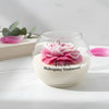 Round glass jar candle with white wax and detailed pink peony flower top, labeled "Mahogany Teakwood".