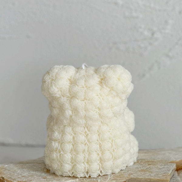 Cream-colored 3D rose teddy bear-shaped candle with textured floral surface.