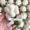 White tulip-shaped candle bouquet tied with a pale gray ribbon, set of 10 candles in background.