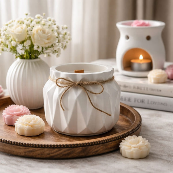 White ceramic diffuser with a wooden tray, flowers, and candles on a neutral background