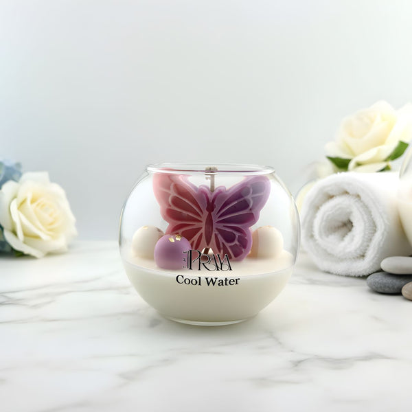 Round glass jar candle with purple butterfly wick and white wax labeled Cool Water.