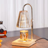 Electronic candle warmer lamp with ribbed amber glass shade on wooden base.