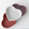 Set of three heart-shaped trays in white, mauve, and terracotta colors, matte finish.