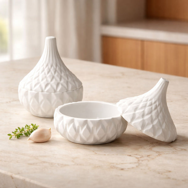 White ceramic jar with textured diamond pattern and matching lid on marble countertop.