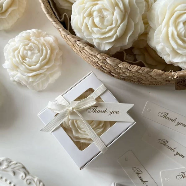 Set of white peony-shaped candles with intricate petal details, presented in a white gift box with ribbon and "Thank you".