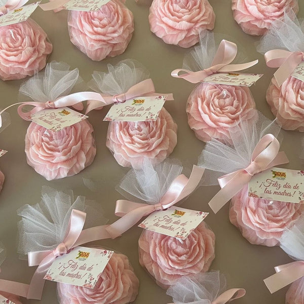 Set of 10 light pink peony-shaped candles wrapped in tulle with pink ribbon bows and gift tags.