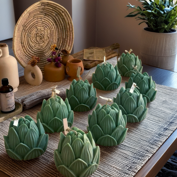 Set of green lotus flower candles arranged on a woven placemat on wooden table.