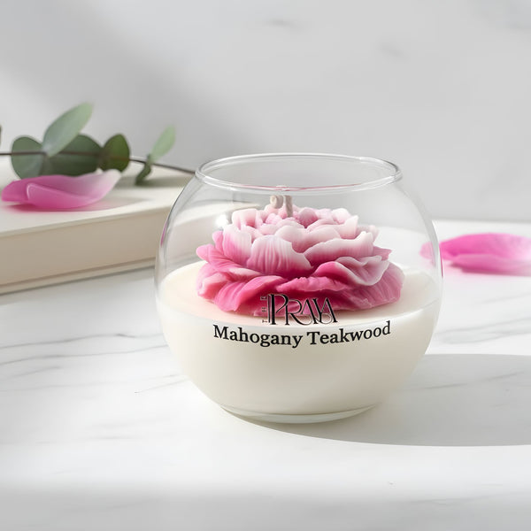 Round glass jar candle with white wax and detailed pink peony flower top, labeled "Mahogany Teakwood".