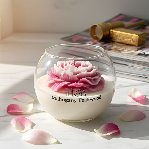 Round glass jar candle with a detailed pink peony flower wax design and mahogany teakwood scent label.
