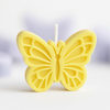 Yellow butterfly-shaped candle with detailed wing patterns and a white wick center.