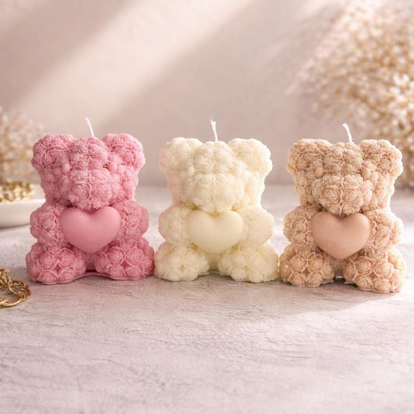 Set of three 3D teddy bear candles made of rose-shaped wax in pink, cream, and beige, each holding a heart.