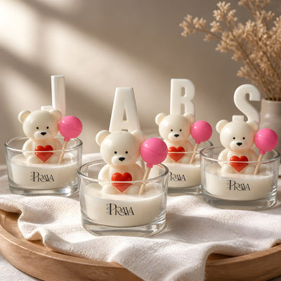 Candle holders with teddy bear designs and 'PRAYA' branding on a wooden tray.