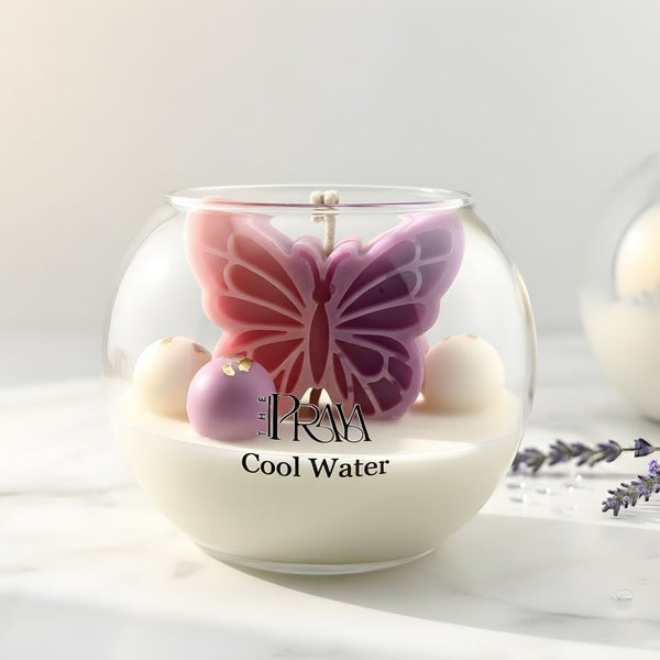 Round glass jar candle with a pink and purple butterfly-shaped wax center and white wax base labeled "Cool Water".