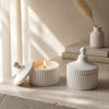 Ceramic striped soy candle with wooden wick creating a cozy and elegant home ambiance