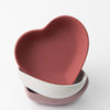 Stack of heart-shaped multipurpose trays in pink, white, and mauve colors with smooth matte finish.