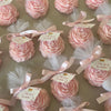 Small pink peony flower scented candles wrapped in white tulle with pink ribbon and gift tags.